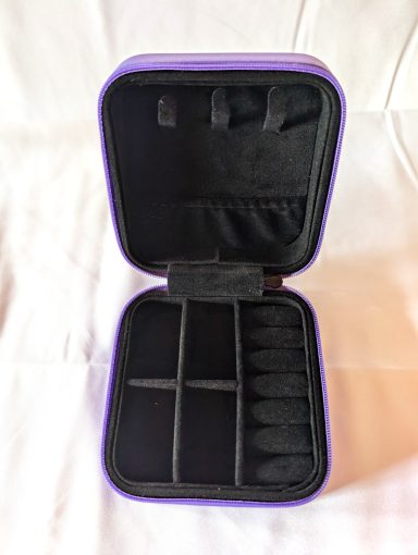 Jewelry box interior in black velvet with holders and compartments.