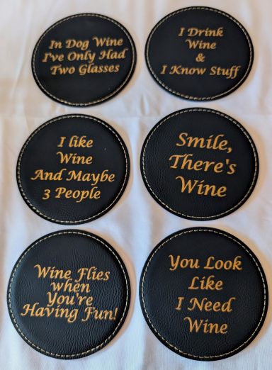 Black leatherette coasters with gold engraving in wine-lovers theme.
